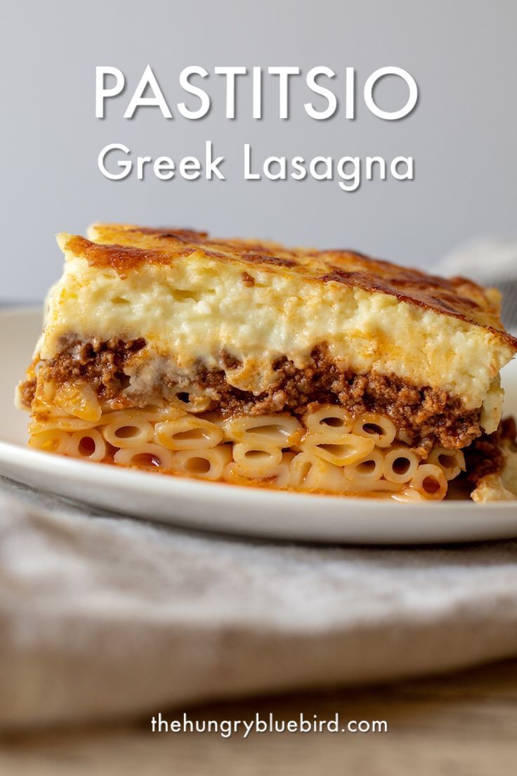 a white plate topped with lasagna covered in cheese and meat sauce on top of it