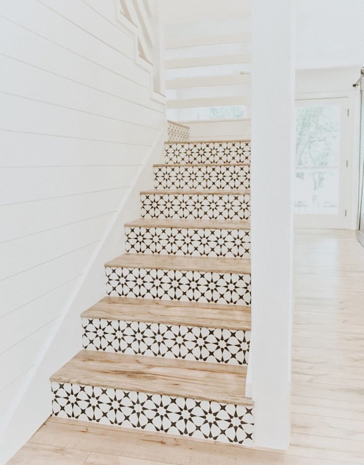 the stairs are decorated with black and white tiles on each hand painted stair treads