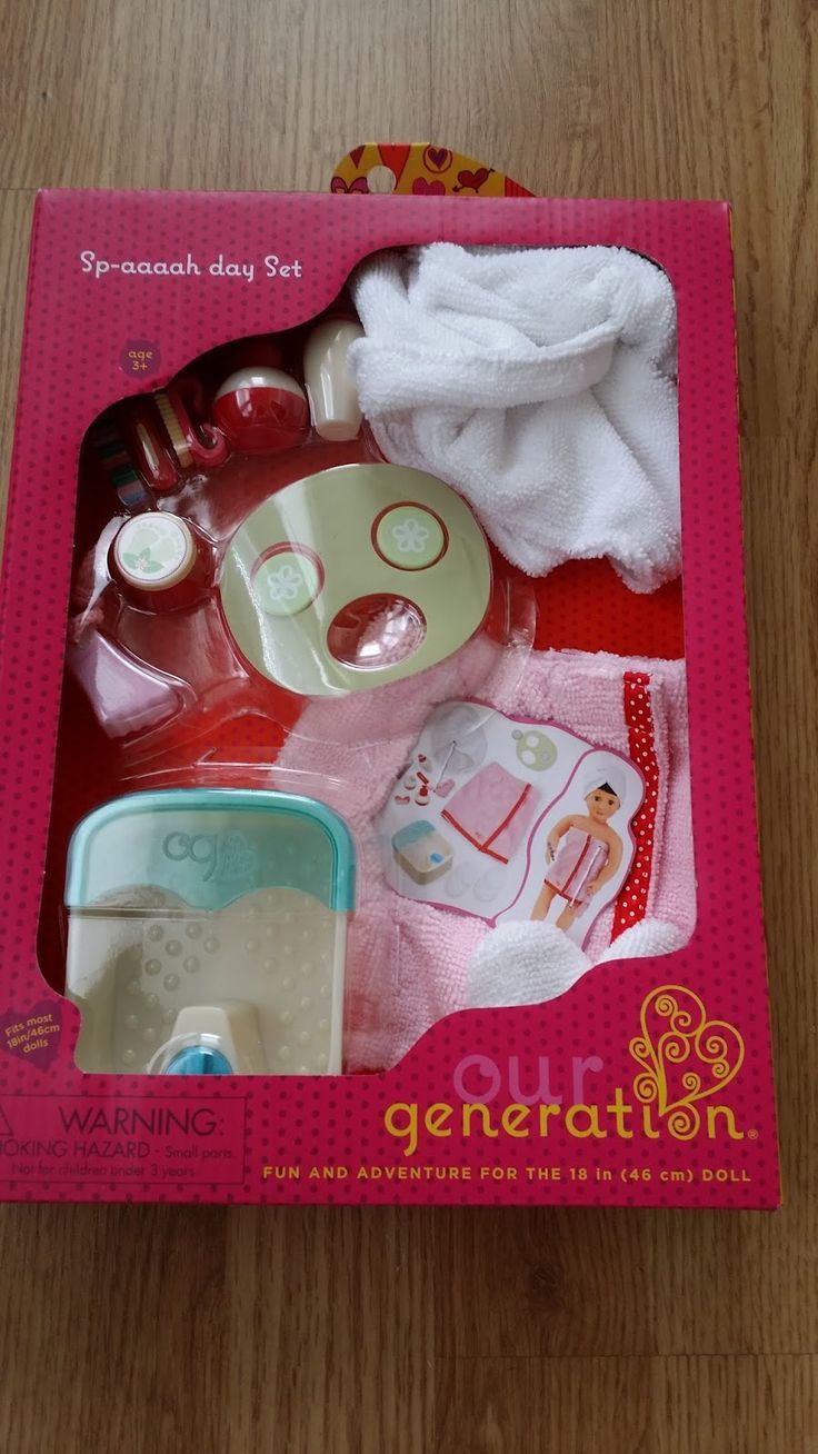 the contents of a doll's diaper set in its box on a wooden floor