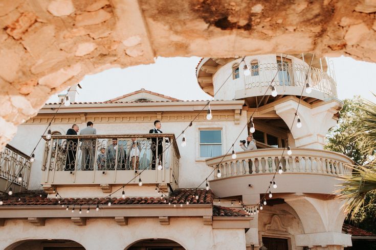 people are standing on the balcony of a house