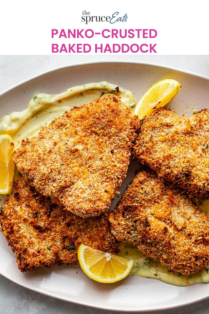 some fried food on a white plate with lemon wedges