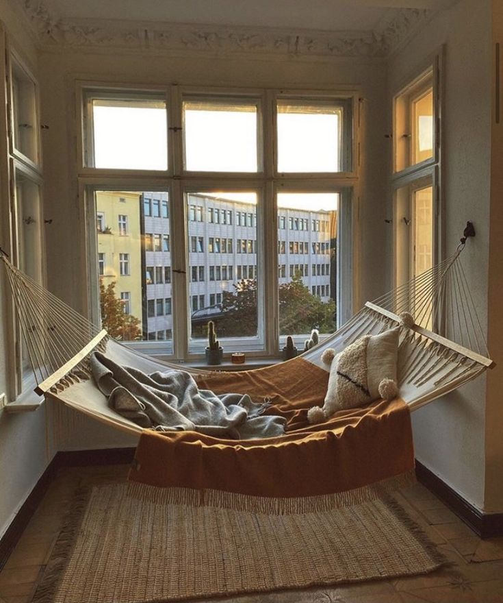 a hammock hanging in front of a window