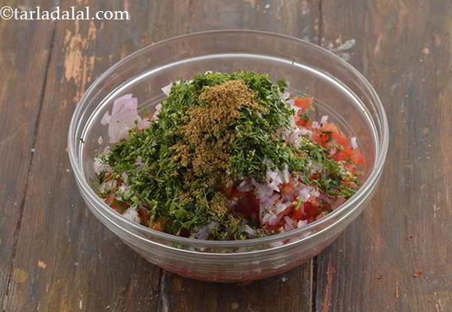 a glass bowl filled with chopped vegetables on top of a wooden table