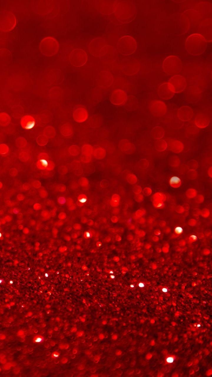 red glitter wallpaper with lots of small dots on it's surface and the background is blurry