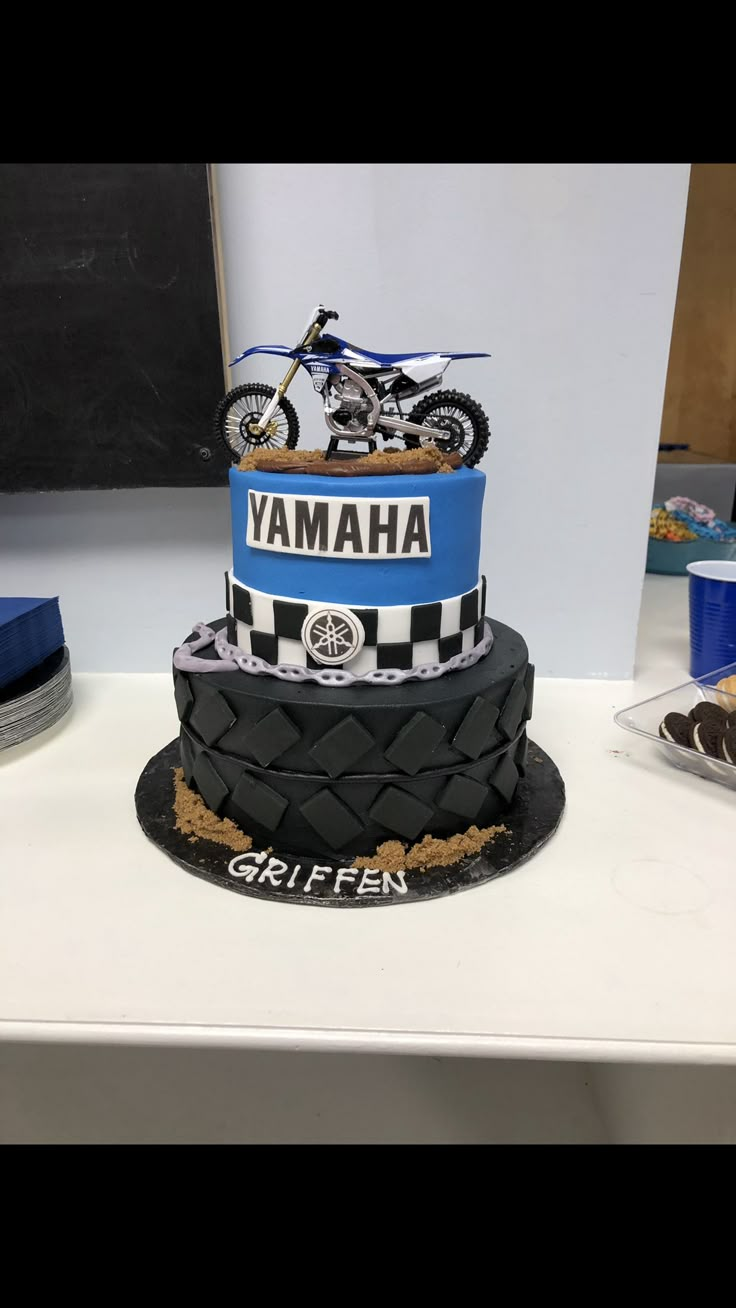 a motorcycle themed cake is on display at the event, with other items around it