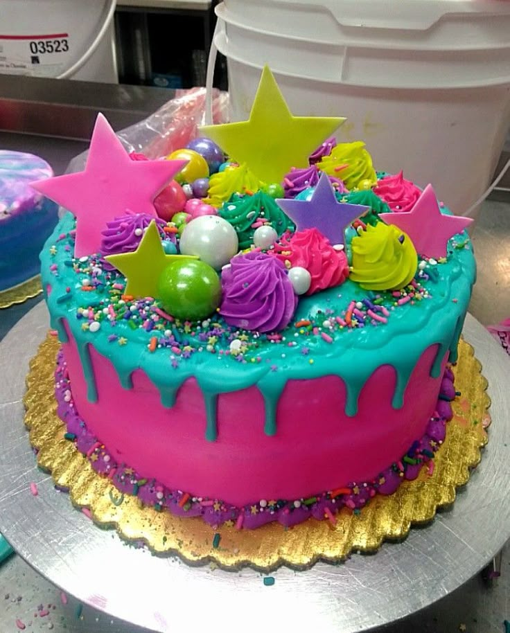 a birthday cake with sprinkles and stars on it sitting on a table