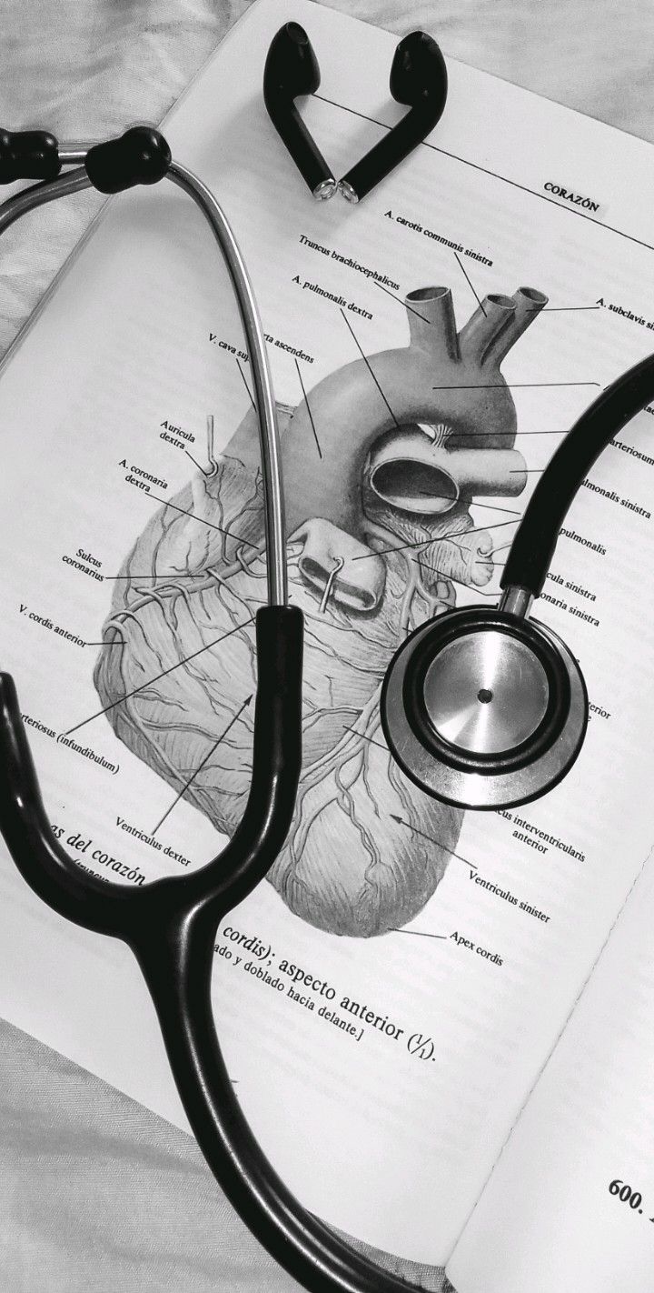 a stethoscope laying on top of an open book with a diagram of the human heart