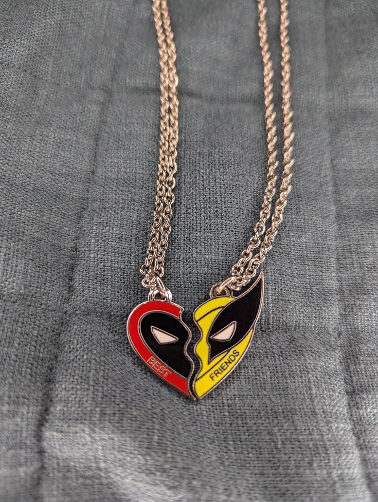 This charming necklace features a unique pendant designed to symbolize friendship. The pendant is split diagonally into two halves, each showcasing Deadpool with large black eyes and wolverine One half is vibrant red with the word "BEST" inscribed, while the other half is bright yellow with "FRIENDS" written on it. The pendant pieces fit together perfectly, making it an ideal gift for best friends to share. The chain is a twisted metal design, adding a touch of elegance to the playful pendant. Best Firend Necklaces Marvle, Best Friends Necklace, Friends Necklace, Deadpool And Wolverine, Twisted Metal, The Other Half, Black Eyes, Friend Necklaces, Other Half