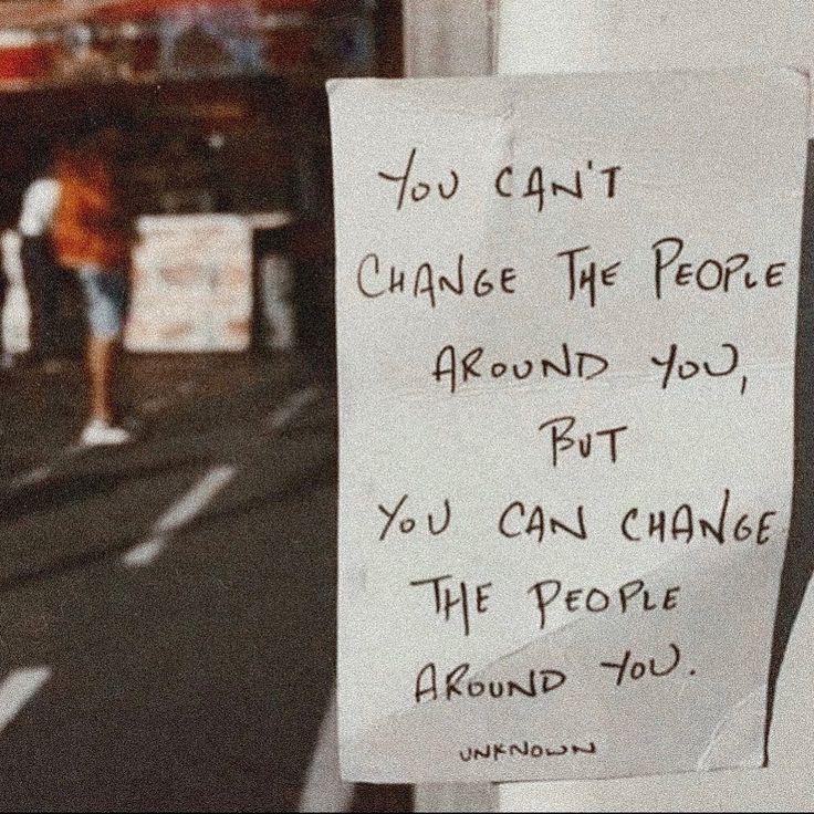 a sign posted on the side of a building that says you can't change the people around you but you can change the people around you