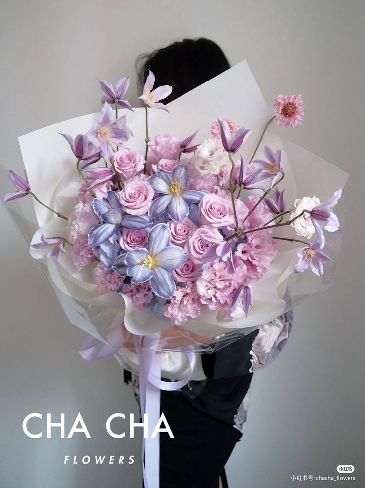 a woman holding a bouquet of flowers in her hands