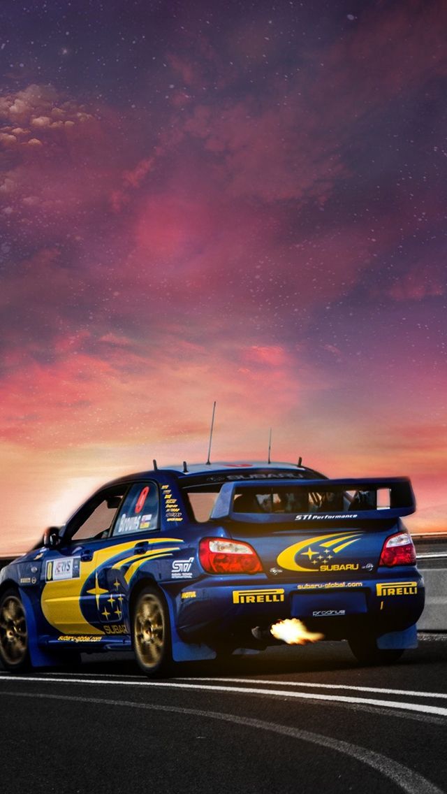 the car is driving down the road in front of an orange and blue sky with stars