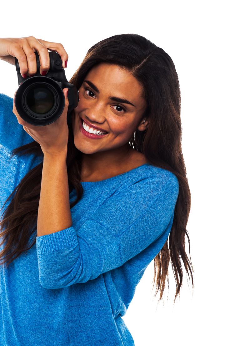 a woman holding a camera up to her face with both hands and smiling at the camera