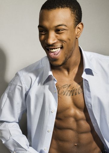 a shirtless man is smiling and posing for the camera