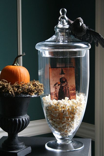 a glass jar filled with rice next to a pumpkin