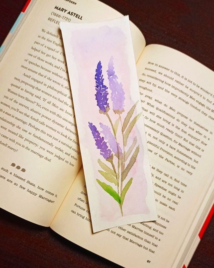 an open book with a watercolor painting of purple flowers on the cover and inside