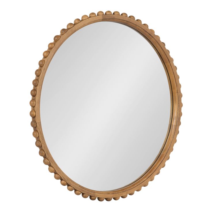 a round wooden mirror with beading around the edges and an oval frame, on a white background