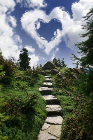 a stone path with a heart shaped cloud in the sky