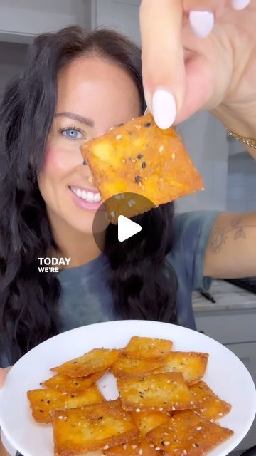 a woman is holding up some food to her face and she is smiling at the camera