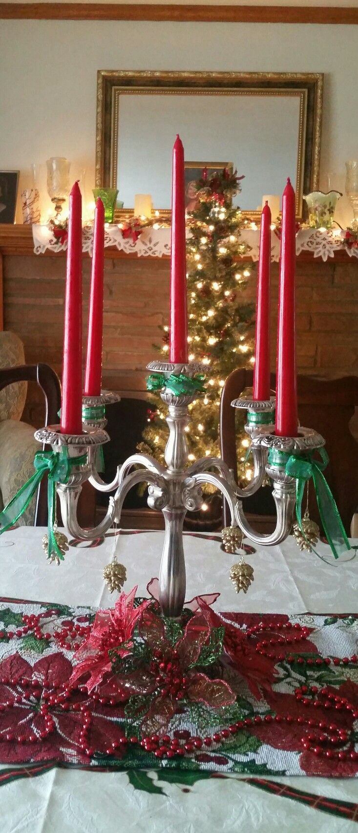 a candelabra with red candles on it in front of a christmas tree