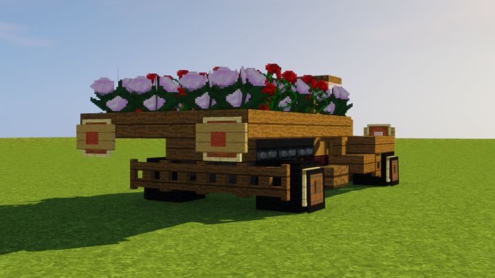 a truck with flowers in the back is parked on grass and there are no people around it