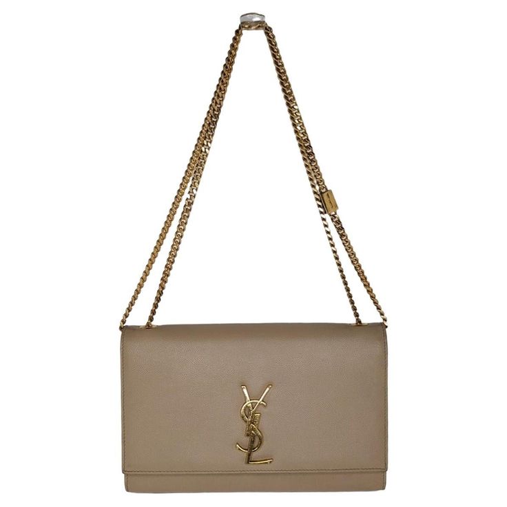 An iconic insignia nods to the Parisian fashion house's heritage on this chic shoulder bag designed in perfect proportions. Retail $2,400. Designer: YSL Saint Laurent Material: 100% Calfskin Origin: Italy Color(s): Dark Beige Measurements: 9 ½"W x 6"H x 2"D Strap Drop: 10 ¼" double; 19 ½" single Interior Lining: Grosgrain Opening/Closure: Flap top with YSL logo medallion snap Interior Pockets: One slip Hardware: Gold-tone metal Includes: Complimentary dust bag, care booklet and Entrupy COA Overa Ysl Saint Laurent, Ysl Logo, Parisian Fashion, Dark Beige, Chain Shoulder Bag, Parisian Style, Gold Tone Metal, Fashion Handbags, Purses Crossbody