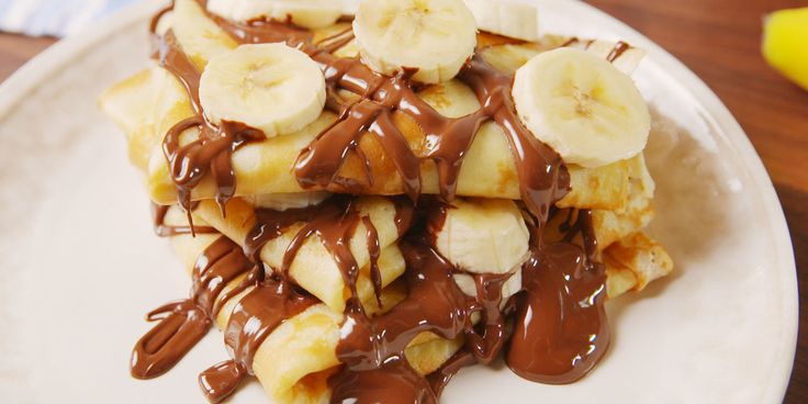 bananas and chocolate sauce on top of pancakes