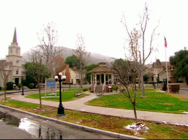 a street with houses and trees in the background