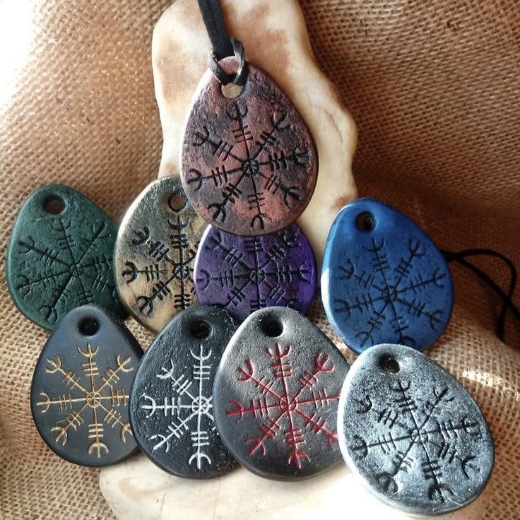 six different colored stone pendants sitting on top of a rock