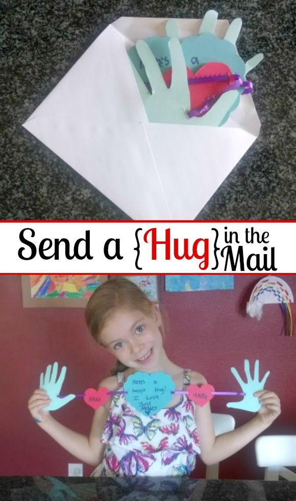 a girl is holding up her handprinted heart and the words send a hug in the mail