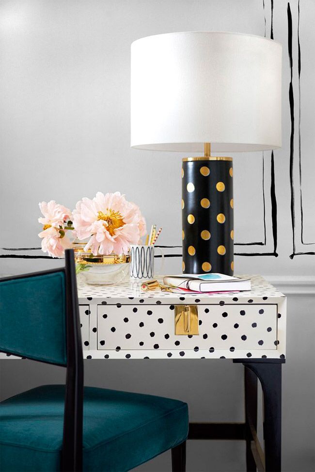 a desk with a polka dot lamp on it and a blue chair next to it