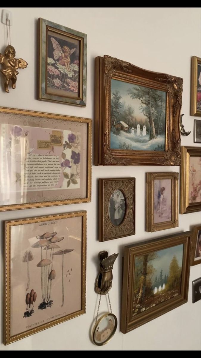 there are many framed pictures on the wall and one has a clock hanging from it