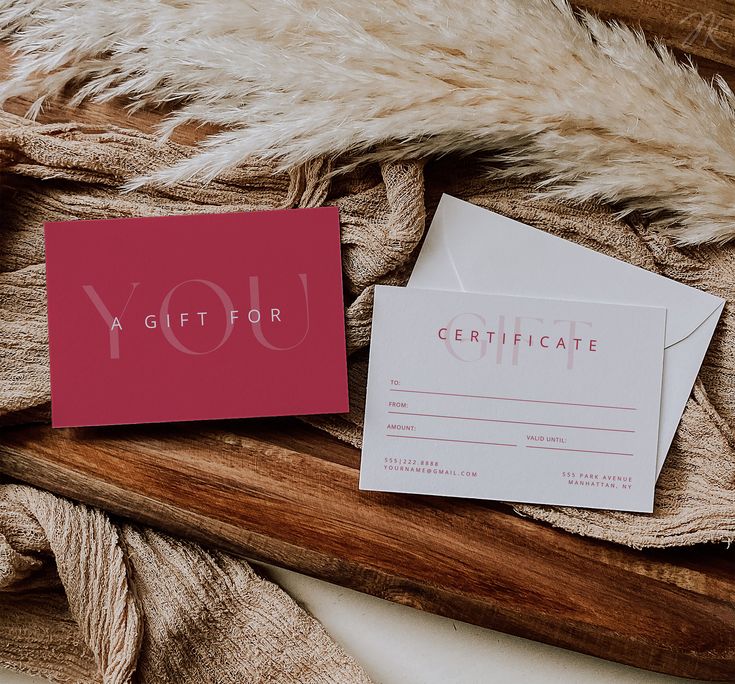 a pink card with the word you on it next to a white envelope and some fur