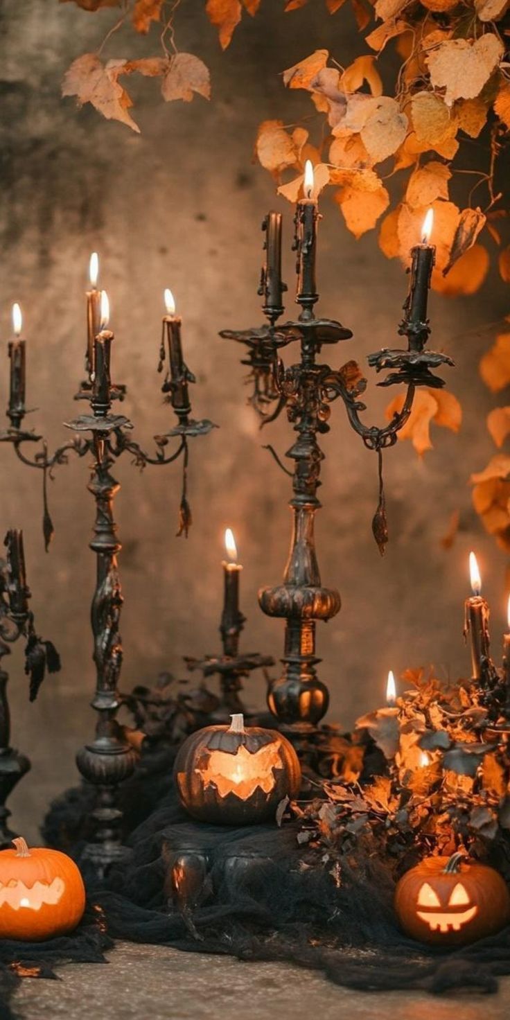 a table topped with lots of candles and pumpkins