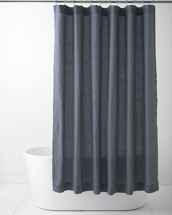 a gray shower curtain hanging on the side of a bathtub