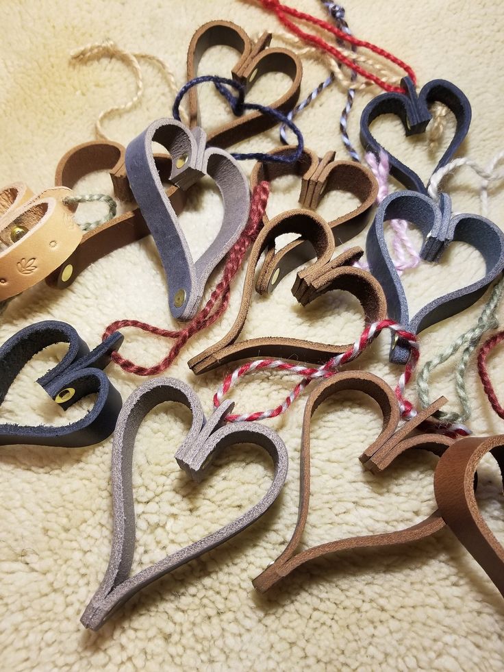 a bunch of different colored wooden hearts on a white carpet