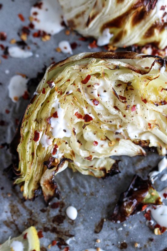 an artichoke is sitting on a baking sheet with other food items around it