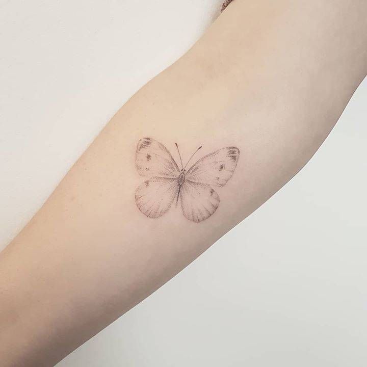 a small butterfly tattoo on the arm