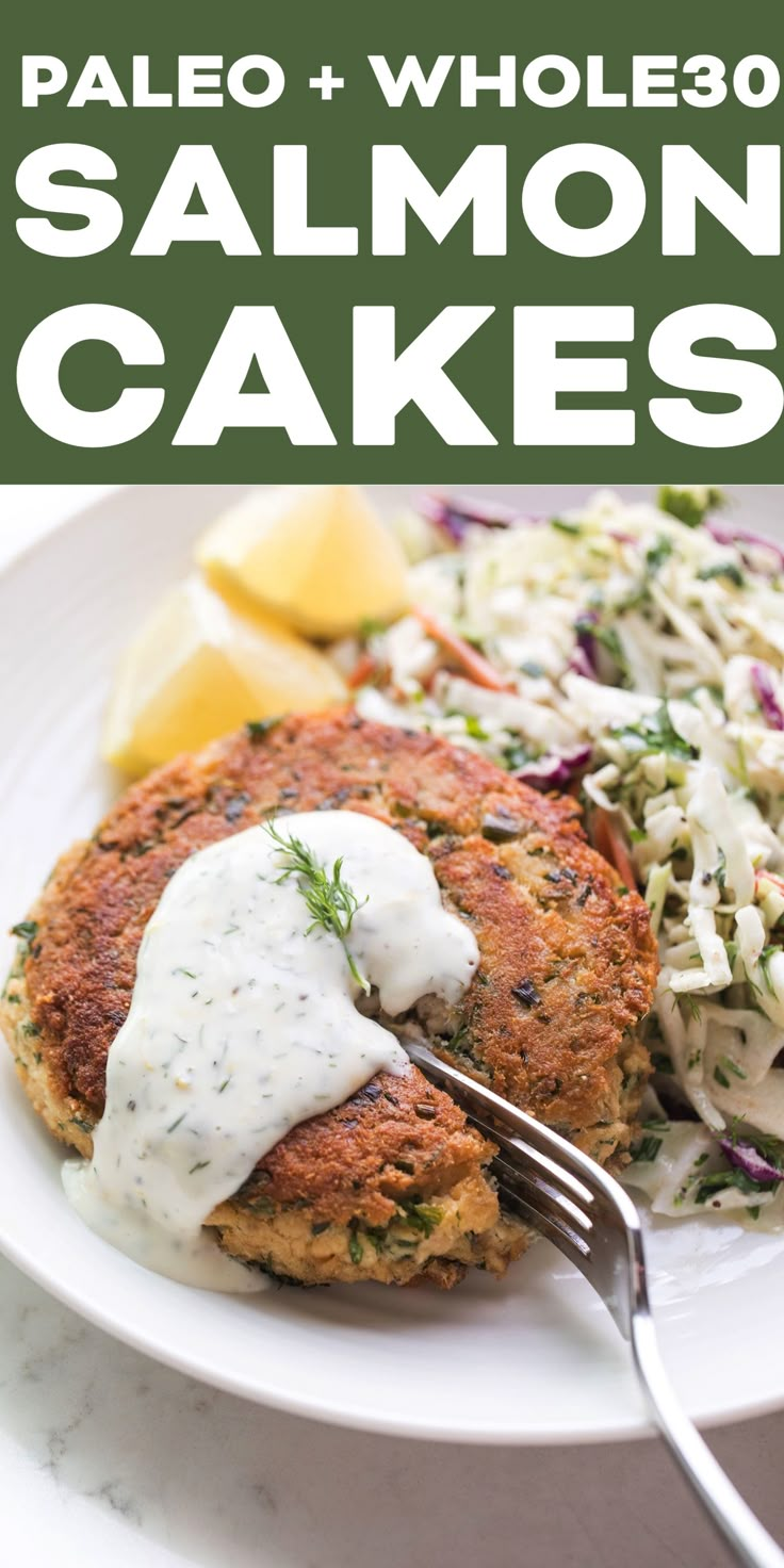 salmon cakes on a plate with coleslaw and lemon wedges in the background