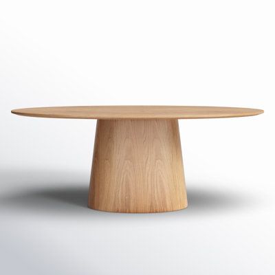 a round wooden table with no one around it on a plain white surface in the background