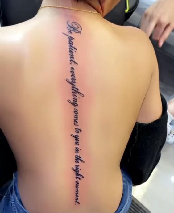 the back of a woman's upper body with writing on her left shoulder and right arm