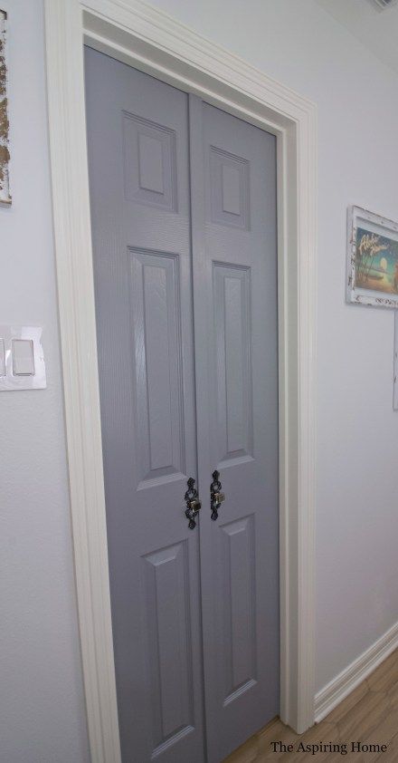 two gray doors in the corner of a room