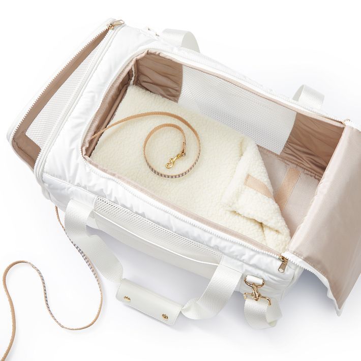 the inside of a white bag with jewelry in it on a white surface, next to a gold chain