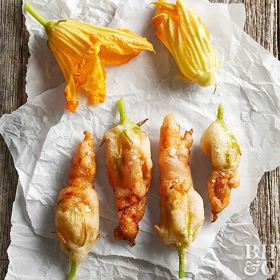 four different types of food sitting on top of a piece of wax paper next to an orange flower