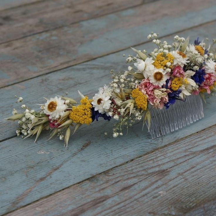 a comb with flowers on it sitting on a wooden table