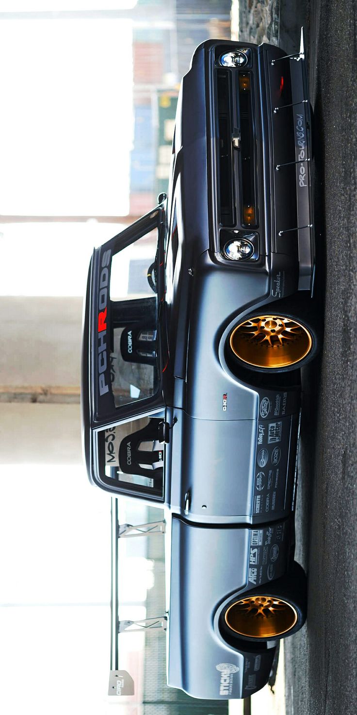 a car parked next to a building with its door open and some wheels on it