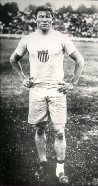 an old black and white photo of a man in shorts standing with his hands on his hips