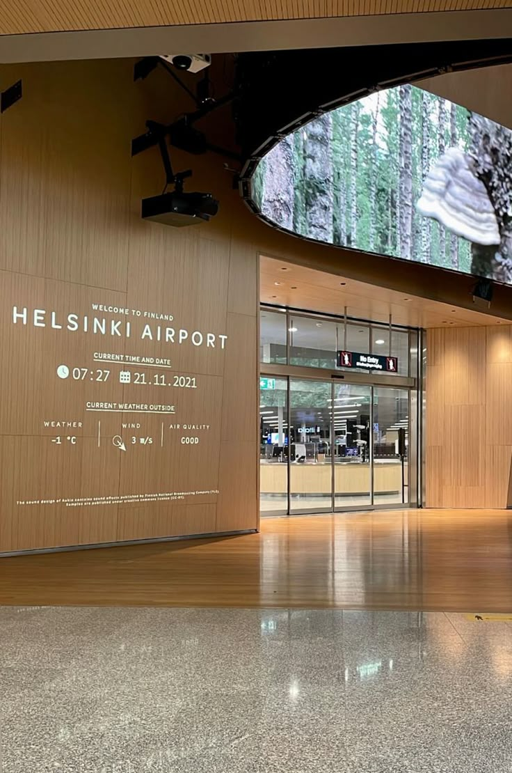 the entrance to helsinki airport is shown in an empty room with wood paneling