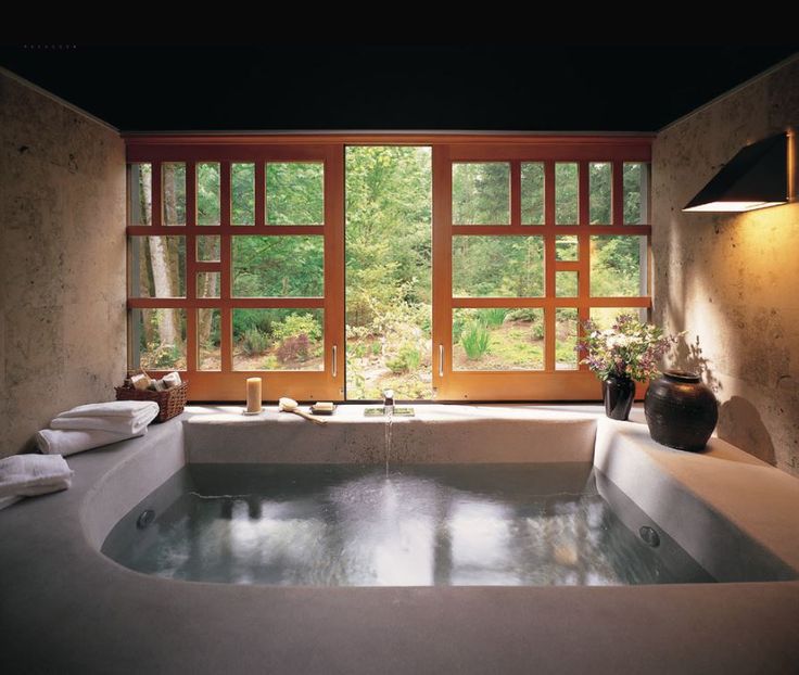 an indoor jacuzzi tub in front of large windows