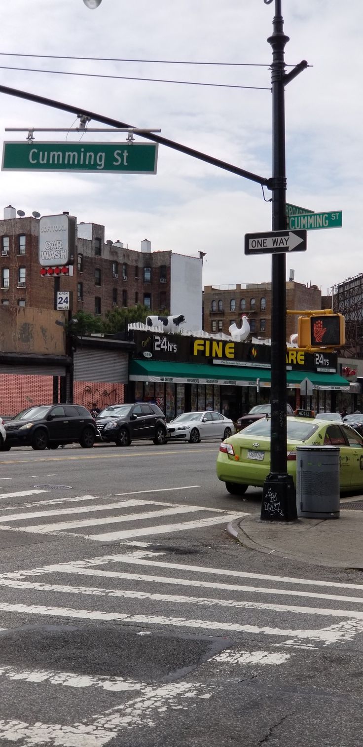 an intersection with cars and street signs in the background