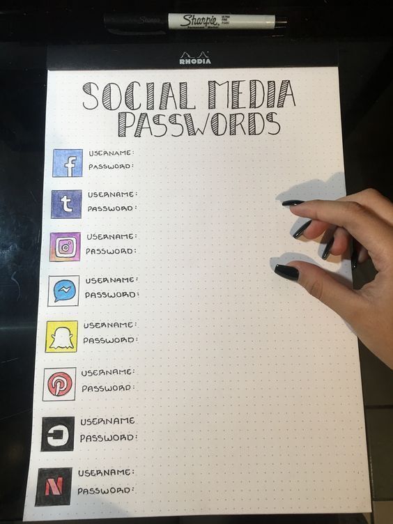 someone is holding their hand on top of a social media passwords sheet with icons